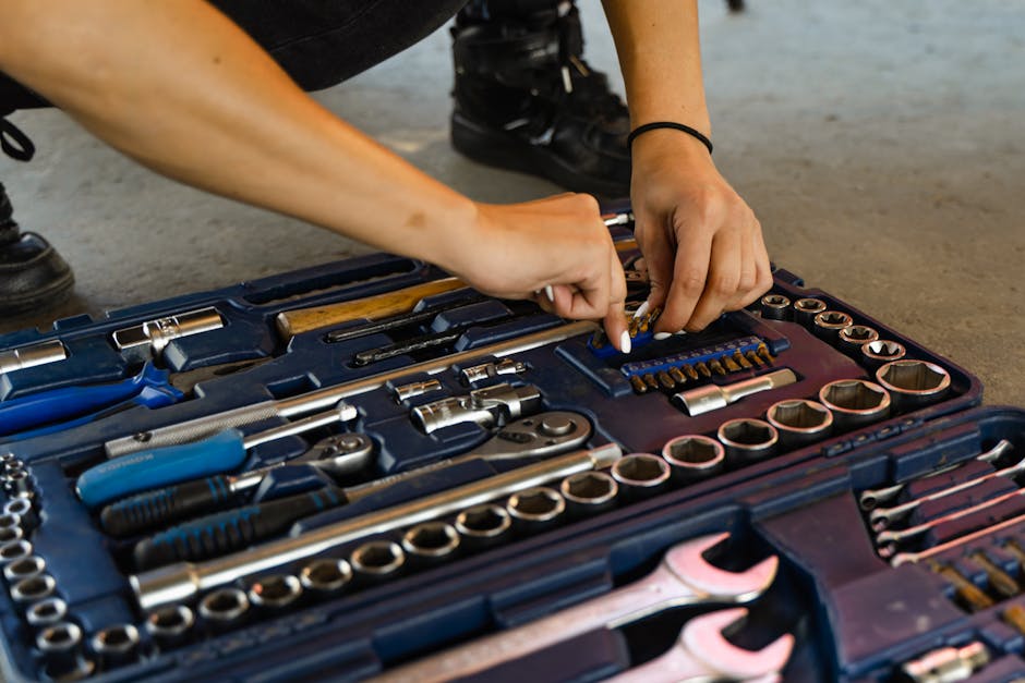 Hands selecting a tool from a versatile, well-organized toolbox for repair tasks.